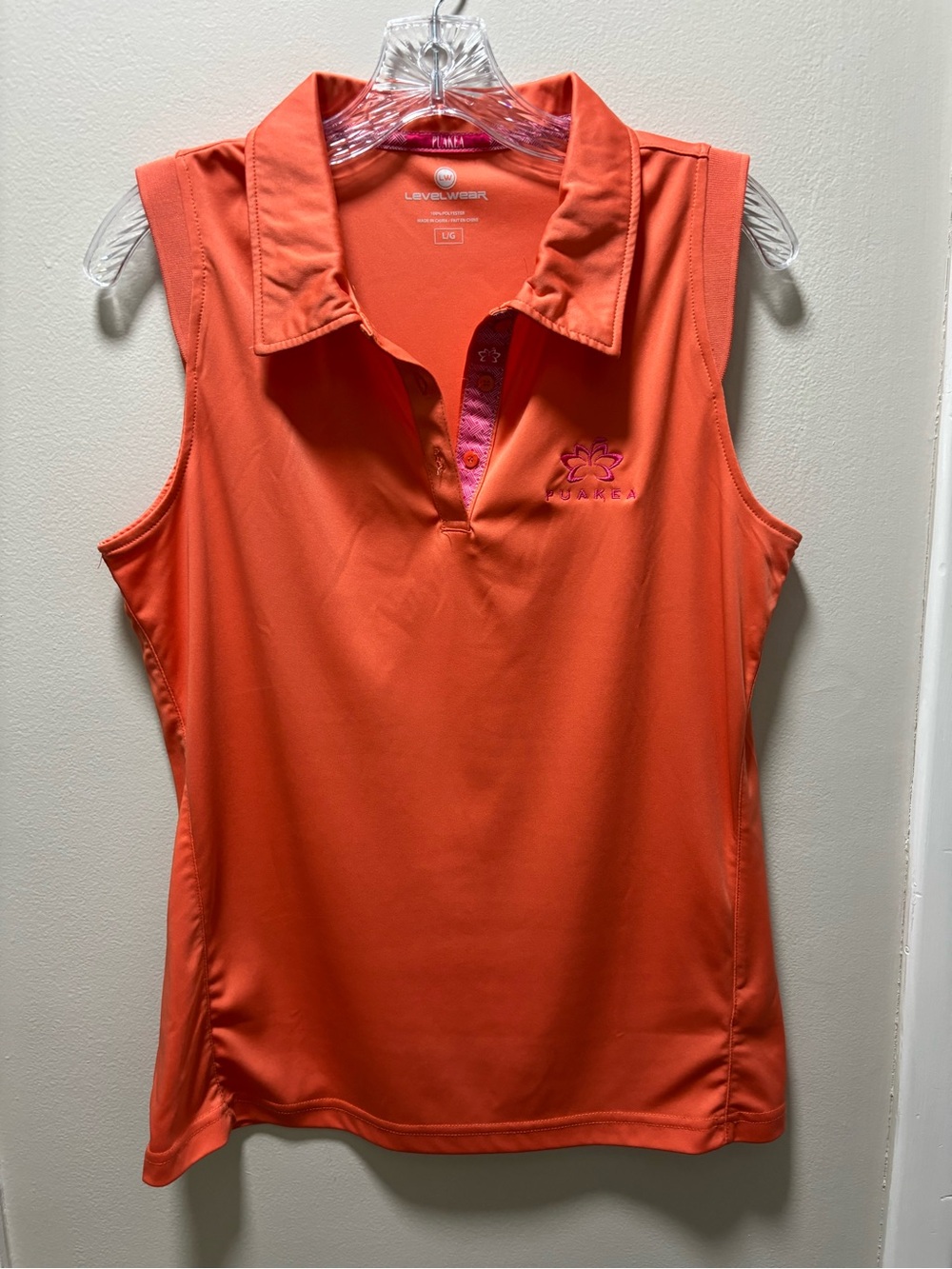 Women's Large sleeveless polo in a bright coral orange Puakea Hawaiian Logo